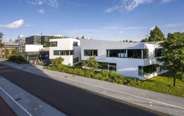 Modern wit kantoorgebouw aan de Fred. Roeskestraat met grote ramen en omliggend groen.